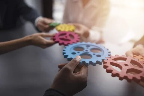People holding and connecting kogwheels